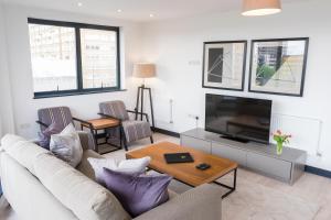 伦敦阿尔德盖特城市公寓的带沙发和电视的客厅