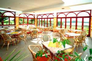 黑灵斯多夫高登湖畔酒店的一间空餐厅,配有桌椅和窗户