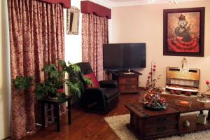 珀斯The Spanish Guesthouse, pets considered的客厅配有平面电视和椅子。