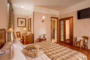 罗马阿尔伯格奥托森托酒店的卧室配有一张大床,墙上配有电视