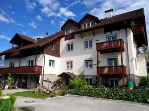 沃尔特湖畔韦尔登Haus Friedburg的白色的大建筑,设有木制阳台