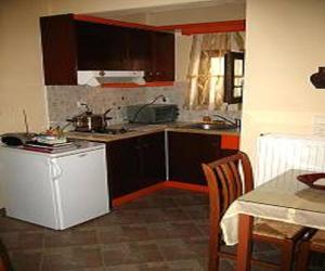 纳克索乔拉佩西恩斯黛拉酒店的厨房配有棕色橱柜和一张桌子