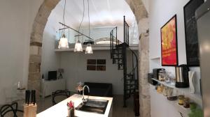 锡拉库扎卡西纳特伦托度假屋的一个带拱门的房间,配有柜台和桌子