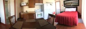 圣弗拉维圣福拉维汽车旅馆的一间小厨房,小房间内设有一张红色的床