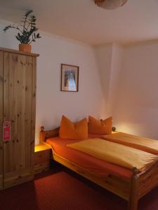 德累斯顿罗西维兹酒店的一间卧室配有带橙色枕头的木床