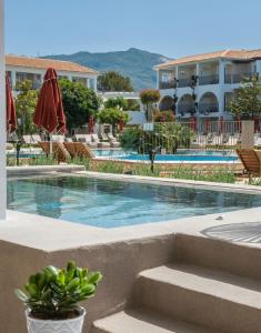 卡拉马孔Bitzaro Grande Hotel & Suites的一座带椅子的游泳池以及一座建筑