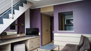 卢森堡奥利维尔酒店的客厅拥有紫色的墙壁和楼梯
