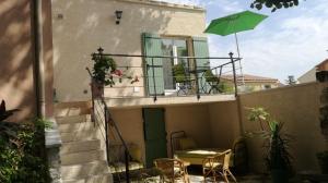 蒙法维伯尔尼与米歇尔住宿加早餐旅馆的阳台配有桌子和绿伞。