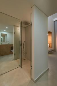 卡拉马孔Bitzaro Grande Hotel & Suites的玻璃门,位于一个带淋浴的房间