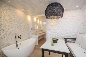 纳克索乔拉Cyano Suites的浴室配有白色浴缸、盥洗盆和浴缸。