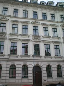 莱比锡Zentrales hochwertiges Gründerzeit-Apartment Thomasius的一座白色的大建筑,有很多窗户