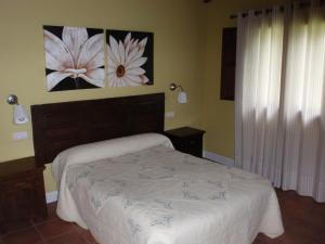 埃兰特克索韦Casa Rural Ogoño Mendi的卧室配有一张床,墙上挂有绘画作品