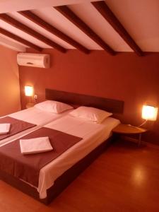 阿赫洛伊Guest House Hristovi的一间卧室配有一张大床和两条毛巾