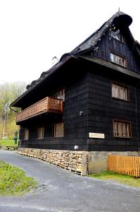 Dolní BečvaChata Mir的一间位于客房一侧的黑色房子,设有一个阳台