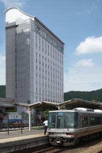 大津京都大津别馆酒店的建筑物前方轨道上的火车