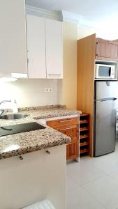 内尔哈Central Nerja的厨房配有白色橱柜和不锈钢冰箱
