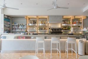 卡萨尔博瑟蒂Hotel Turismo Europa的餐厅内带白色凳子的酒吧