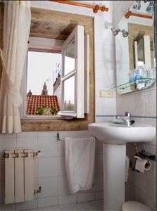 圣地亚哥－德孔波斯特拉阿方索旅馆的一间带水槽和卫生间的浴室以及窗户。