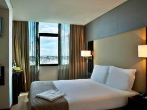 里斯本图里姆阿拉米达酒店的酒店客房设有一张床和一个大窗户
