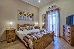 瓦莱塔Valletta Apartments 19的一间卧室配有一张大床和电视