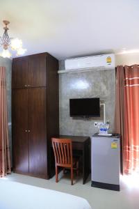 坤西育府纳瓦度假酒店的客房设有书桌、冰箱和电视。