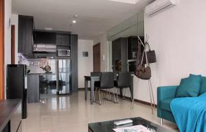 雅加达绿湾凯文公寓的客厅配有蓝色的沙发和桌子