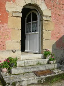 塞尔吉玫瑰农庄客栈的砖砌建筑中一扇门,有楼梯和鲜花