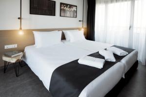 塞萨洛尼基White Luxury的酒店的客房 - 带2张带白色枕头的床