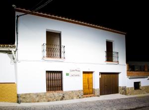 Segura de LeónCasa Rural La Fuente的白色的建筑,设有两扇门和两扇窗户