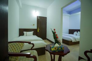 达卡普罗加提酒店有限公司的酒店客房,配有两张床、椅子和桌子