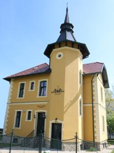 凯斯特海伊Anna Villa的一座黄色的大建筑,设有钟楼