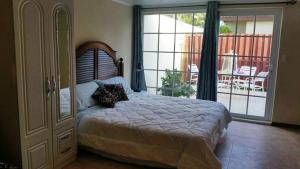 棕榈滩Sandpiper Beach Apartments的一间卧室设有一张大床和一个滑动玻璃门