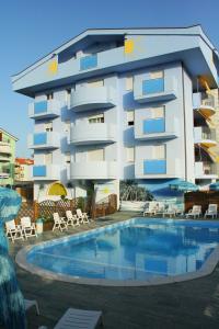 朱利亚诺瓦蓝色海洋公寓式酒店的建筑前的一座带游泳池的建筑