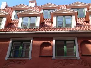 里加圣彼得精品酒店的一座红色的建筑,上面有窗户
