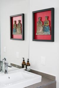墨西哥城La Palomilla Bed & Breakfast的浴室水槽上方墙上的两张框图