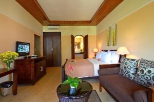 圣吉吉龙目岛日落酒店的酒店客房,配有床和沙发