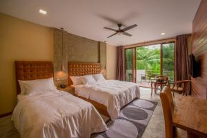 达拉万度基哈海滩酒店的一间卧室设有两张床和大窗户
