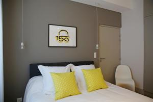 阿尔比Appartements Numeroa的一间卧室配有黄色和白色枕头的床