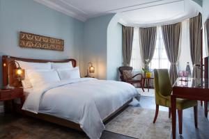 海法卡梅拉精品酒店的一间卧室配有一张大床、一张桌子和一把椅子