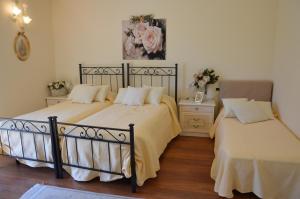特雷梅佐伊乐甘萨公寓的一间卧室配有两张床和一张鲜花桌