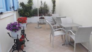 费拉罗莎别墅酒店的庭院配有白色的椅子和桌子,鲜花盛开