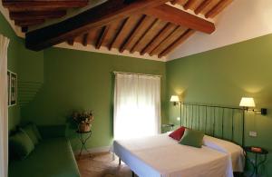 圣吉米纳诺杜慈别墅酒店的绿色卧室配有床和沙发