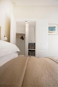 剑桥The Grapevine Studio的白色卧室设有一张大床和一个衣柜