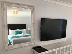 巴特曼斯贝亚拉伦汽车旅舍 的配有床和电视的房间的镜子