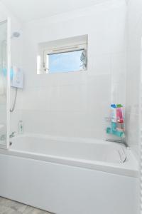 爱丁堡爱丁堡海滨公寓的白色的浴室设有浴缸和窗户。