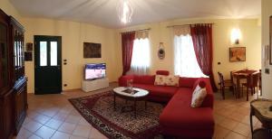 因佩里亚Casa vacanze Cristina的客厅配有红色沙发和电视