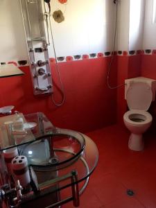 丘斯滕迪尔Guest House Pautalya的红色的浴室设有卫生间和玻璃水槽。
