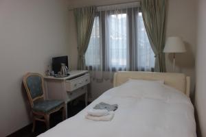 屋久岛拉伊斯拉博塔塞酒店的一间卧室配有一张床、一张桌子和一把椅子