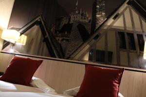 圣米歇尔山特拉斯布拉德酒店的靠窗的一张带红色枕头的床