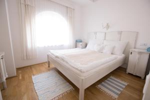 包道乔尼托毛伊Bacchus Apartman - Borbarlang, Badacsony的白色的卧室设有一张大床和一个窗户